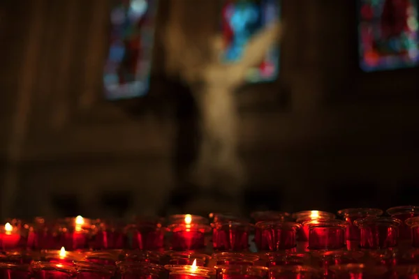 burning candles in glass lanterns in church interior