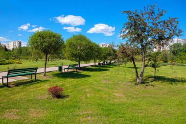 Bahar mevsiminde bankları olan şehir parkı 