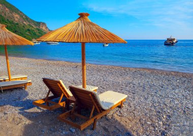 Kumsalda dinlenin. Egzotik şemsiyelerle güneşlenin. 