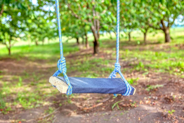 Wooden swing in the garden , rustic playground with handmade swing