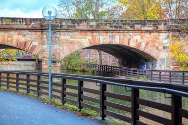 Nehir kenarında denge ve sonbaharda kemerli köprü. 