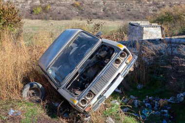 Eski araba çöpe atıldı. Terk edilmiş otomobil çöplükte.