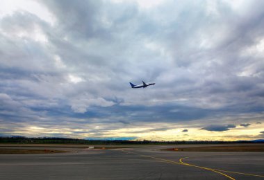 Uçak alçak bulutlara doğru kalkıyor. 