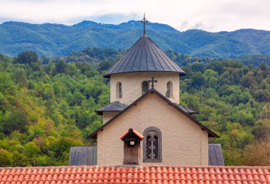 Çan kulesiyle Eski Manastır. Balkan Dağları 'ndaki kilise. Döşemeli çatı ve eski kilisenin bacası.
