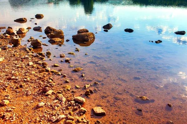 河岸上有透明的水和石头 落水的边缘 — 图库照片