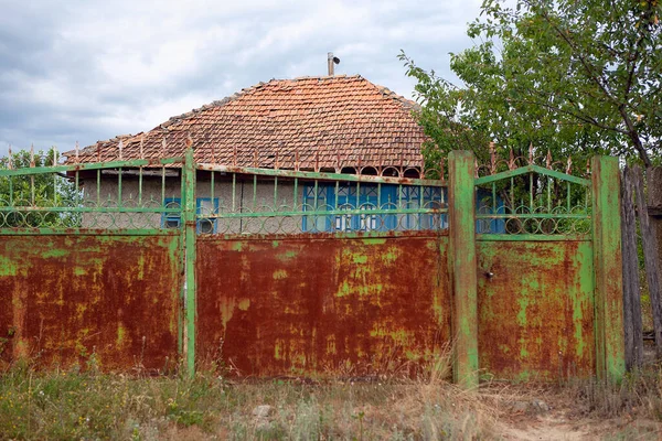 Stary Dom Zardzewiałą Bramą Miejscowości — Zdjęcie stockowe