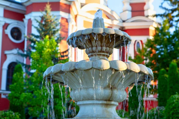 Marble fountain with water cascades . Fountain in the church yard