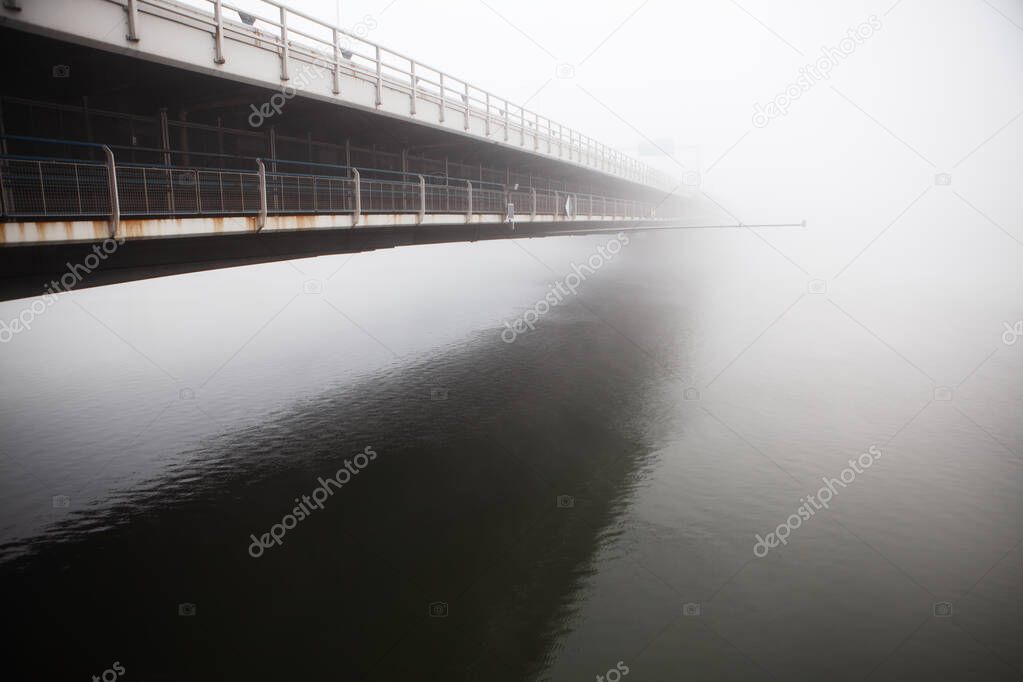 Bridge side view with reflection in the water  . Donaubrucke in the foggy morning