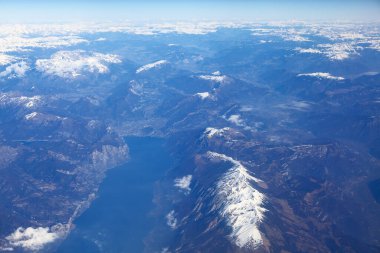 Karlı zirvelerle dağların üzerinde uçuyor