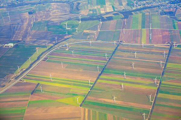 Wind turbines on the green fields , aerial view . Windmills can generate sufficient electricity to power for suburb
