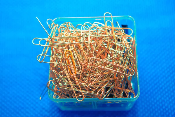 pile of paper clips on blue background