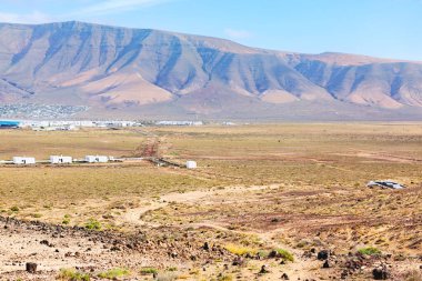 Çürük arazi engebeli volkanik tepelere doğru uzanır. Dağların eteklerinde küçük bir kasaba bulunur. Ender bitki örtüsü ve kayalık toprak Kanarya Adaları 'nda dramatik, güneş yanığı manzarası