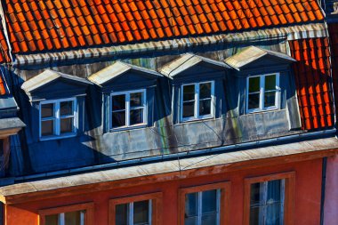 Kırmızı kiremit çatılı ve klasik yatakhane pencereli tarihi mimari farklı gölgeler bırakıyor. Döşemeli çatı, aşağıdaki geniş tavan arasını işaret eden kapalı yatakhaneler içeriyor.