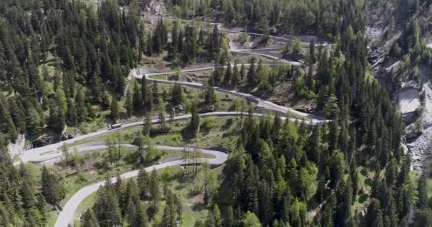 Вид з гори serpentine дорога з легкових та вантажних автомобілів, водіння на зигзаг йти вгору і вниз в Європі Швейцарії 4 к — стокове відео