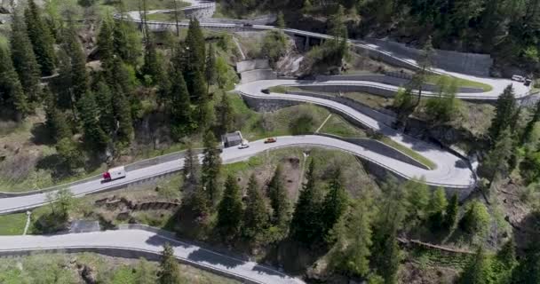 Aerial view of mountain serpentine road with trucks and cars driving on zig zag go up and down in Europe Switzerland 4K — Stock Video