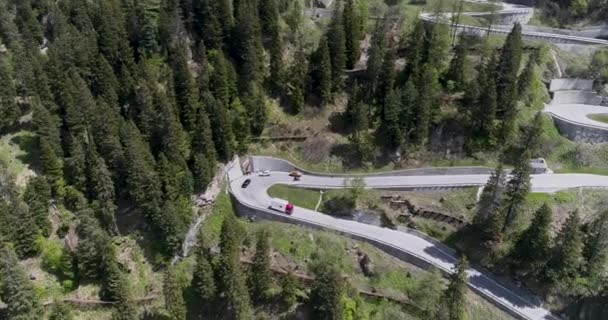 Vista aérea de la carretera serpentina de montaña con camiones y coches que conducen en zig zag subir y bajar en Europa Suiza 4K — Vídeos de Stock