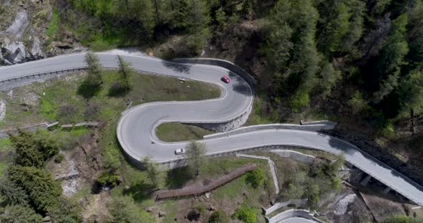 Flygfoto över berget serpentinväg med lastbilar och bilar som kör på zig zag gå upp och ner i Europa Schweiz 4k — Stockvideo