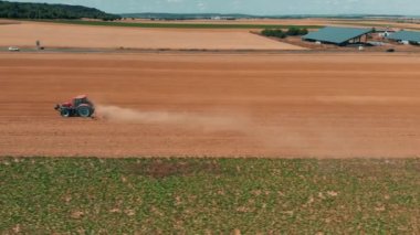 Kırmızı tracor buğday alanında çalışan hava dron görünümü. Tarım ve çevre Avrupa Birliği'ndeki.