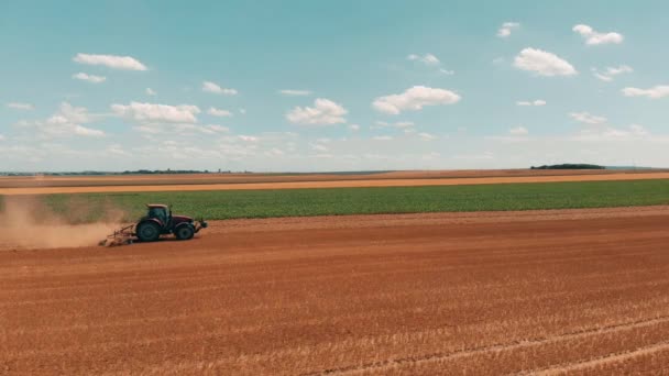 Aerial drönarvy av röda tracor arbetar i vetefält. Jordbruk och miljö i Europeiska unionen. — Stockvideo