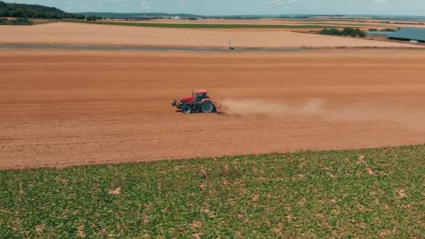 Veduta aerea drone di tracor rosso che lavora nel campo di grano. Agricoltura e ambiente nell'Unione europea . — Video Stock
