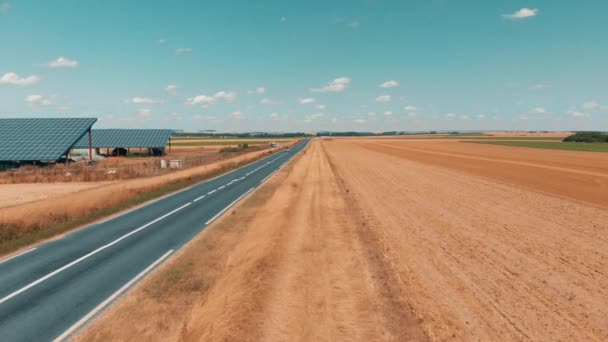 Luchtfoto drone beelden van een kleine zonnepanelen boerderij en weg verkeer — Stockvideo