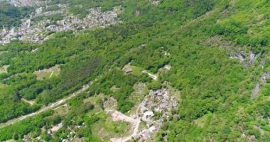 Yeşil tepeler ve vadiler İtalya Alpler'de veya 4k Avusturya'da yypical Alps köyünün havadan görünümü