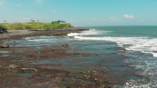 Plaj tropikal üzerinde inişli çıkışlı dalgalar ve kayalıklarla ile çarpıcı havadan görünümü ada Bali Malezya 4k — Stok video