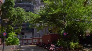 Yüksek yükselen buliding duvarların dışında. Otopark ve yeşil ağaçları motosiklet. Kuala Lumpur, Malezya. Yukarı eğimli. 4k