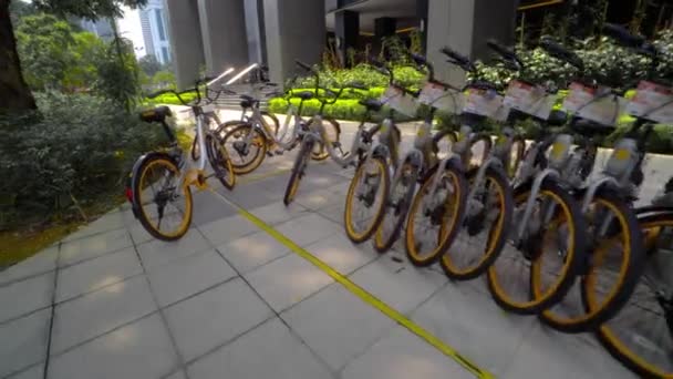 Muitas bicicletas estão em uma fileira no estacionamento de rua em Kuala Lumpur Malásia. Transporte ecologicamente limpo. Vista das rodas. 4K — Vídeo de Stock