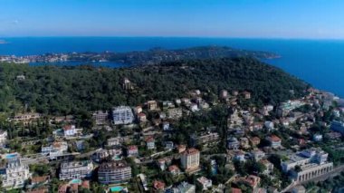 Akdeniz köyü Nice güneş ışık yeşil Hills yakınlarında. çatıları ve dar sokaklar aşağıda. dağlar ve deniz uzakta. Fransa yaz aylarında hava dron görünümü