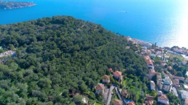 Akdeniz köyü Nice güneş ışık yeşil Hills yakınlarında. çatıları ve dar sokaklar aşağıda. dağlar ve deniz uzakta. Fransa yaz aylarında hava 4 k dron görünümü