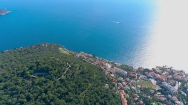 Akdeniz köyü Nice güneş ışık yeşil Hills yakınlarında. çatıları ve dar sokaklar aşağıda. dağlar ve deniz uzakta. Fransa yaz aylarında hava 4 k dron görünümü