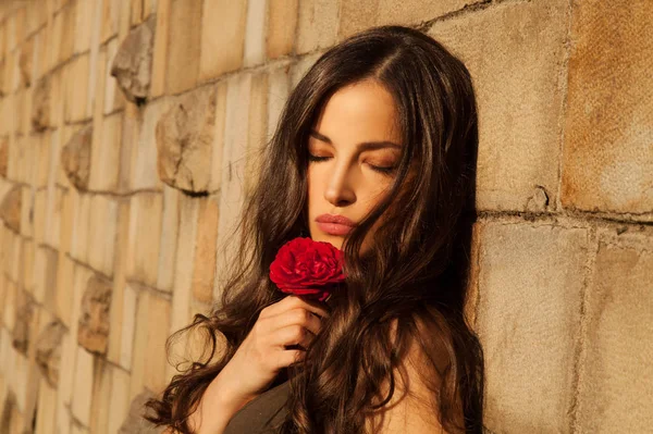 Krásná Mladá Žena Opřen Zeď Drží Červená Růže Slunečný Den — Stock fotografie