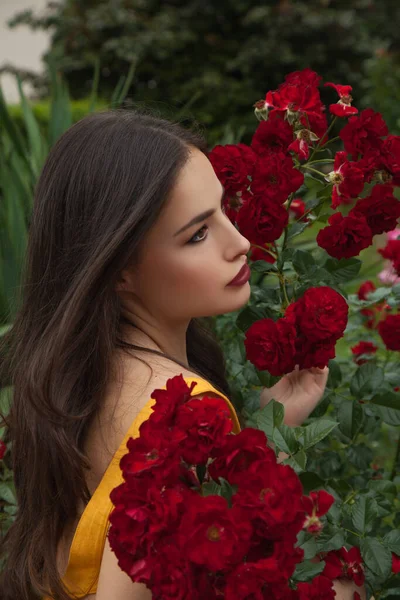赤いバラの美しい若い女性夏の花畑の美しさの肖像画 — ストック写真