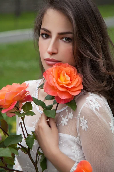 Hermosa Mujer Morena Con Rosa Naranja Retrato Flores Imagen de stock
