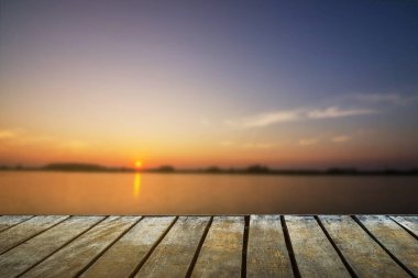 Ürün görüntüleme montajı için peyzaj arkaplanı olan bulanık, güzel günbatımı üzerine boş tahta masa