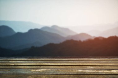 Ürün görüntüleme montajı için peyzaj arkaplanı olan bulanık, güzel günbatımı üzerine boş tahta masa
