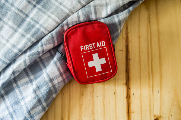 Сумка первой помощи на деревянном фоне
