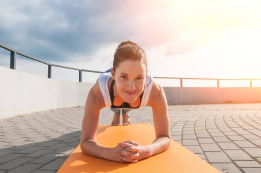 Genç güzel kadın yoga uygulamaları ve nehir dolgu üzerinde derin derin düşünür