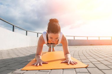 Genç güzel kadın yoga uygulamaları ve nehir dolgu üzerinde derin derin düşünür