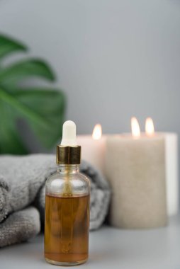 Havlu aromatik mumlar ve doğal organik yağ özü serumuyla birlikte şişe. Aromaterapi ve güzellik. Uyum, denge ve meditasyon kavramı, spa, masaj, rahatlama, güzellik spa tedavisi.