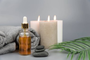 Havlu aromatik mumlar ve doğal organik yağ özü serumuyla birlikte şişe. Aromaterapi ve güzellik. Uyum, denge ve meditasyon kavramı, spa, masaj, rahatlama, güzellik spa tedavisi.