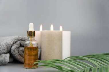 Havlu aromatik mumlar ve doğal organik yağ özü serumuyla birlikte şişe. Aromaterapi ve güzellik. Uyum, denge ve meditasyon kavramı, spa, masaj, rahatlama, güzellik spa tedavisi.