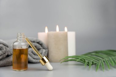 Havlu aromatik mumlar ve doğal organik yağ özü serumuyla birlikte şişe. Aromaterapi ve güzellik. Uyum, denge ve meditasyon kavramı, spa, masaj, rahatlama, güzellik spa tedavisi.