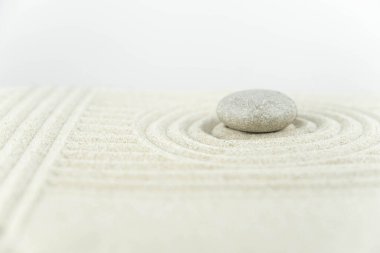 Zen bahçesi. Beyaz ve gri Zen taşlarından piramitler soyut dalga çizimleriyle beyaz kumun üzerinde. Uyum kavramı, denge ve meditasyon, spa, masaj, rahatlama.