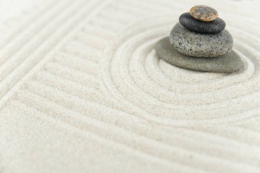 Zen bahçesi. Beyaz ve gri Zen taşlarından piramitler soyut dalga çizimleriyle beyaz kumun üzerinde. Uyum kavramı, denge ve meditasyon, spa, masaj, rahatlama.