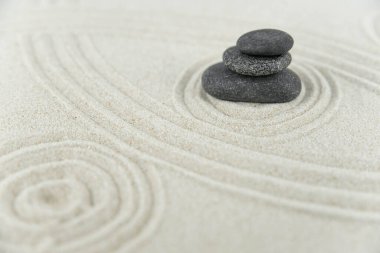 Zen bahçesi. Beyaz ve gri Zen taşlarından piramitler soyut dalga çizimleriyle beyaz kumun üzerinde. Uyum kavramı, denge ve meditasyon, spa, masaj, rahatlama.