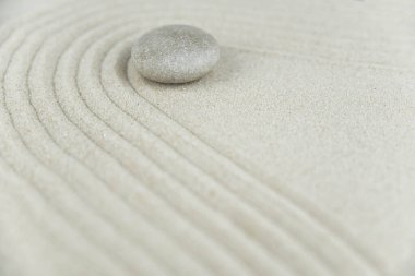Zen bahçesi. Beyaz ve gri Zen taşlarından piramitler soyut dalga çizimleriyle beyaz kumun üzerinde. Uyum kavramı, denge ve meditasyon, spa, masaj, rahatlama.