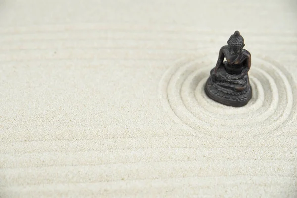 Buddha and abstract Zen drawing on white sand. Concept of harmony, balance and meditation, spa, massage, relax. Zen garden.
