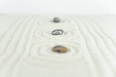 Zen bahçesi. Beyaz ve gri Zen taşlarından piramitler soyut dalga çizimleriyle beyaz kumun üzerinde. Uyum kavramı, denge ve meditasyon, spa, masaj, rahatlama.